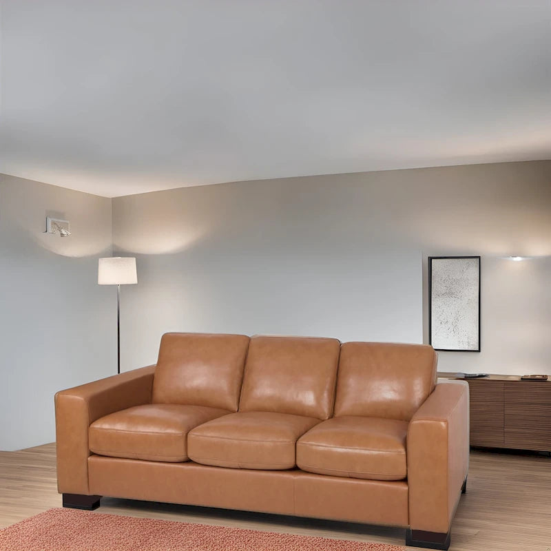 Canapé 3 places haut de gamme en cuir véritable, avec assise profonde et moelleuse et coussins en plumes d'oie pour un confort optimal.