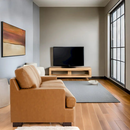 Canapé 3 places haut de gamme en cuir véritable, avec assise profonde et moelleuse et coussins en plumes d'oie pour un confort optimal.