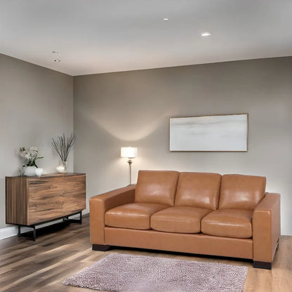 Canapé 3 places haut de gamme en cuir véritable, avec assise profonde et moelleuse et coussins en plumes d'oie pour un confort optimal.