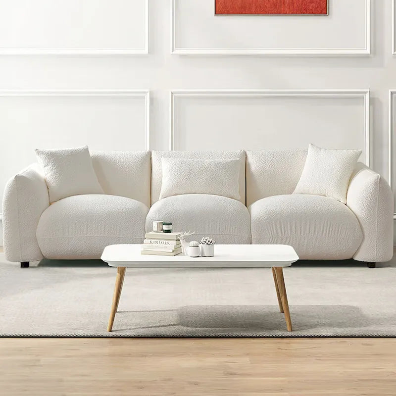 Canapé d'angle blanc confortable et moelleux, garni de duvet d'agneau, avec pouf